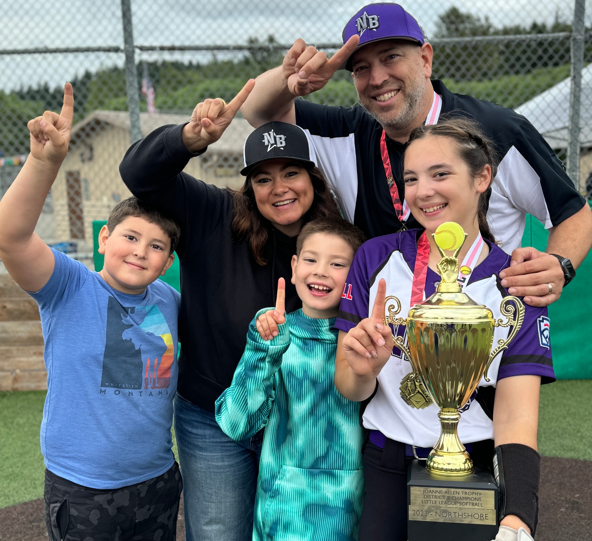 The Poppy Digital family at the ballpark holding the District 8 Champions trophy